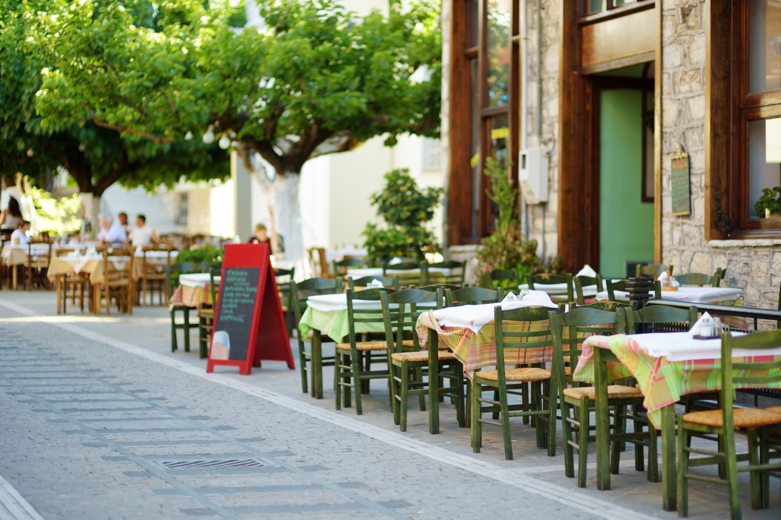 Small outdoor restaurants and cafes at the pedestrian area at center of Kalavryta town near the square and odontotos train station, Greece.